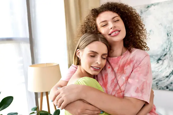 Two women share a warm embrace, radiating love and joy in a bright, inviting space. — Stock Photo