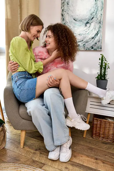Two beautiful young women share a moment of love and laughter in a cozy, inviting space. — Stock Photo