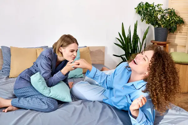 Una giovane coppia lesbica gode del loro tempo, ridendo e giocando in un'atmosfera calda e invitante. — Foto stock