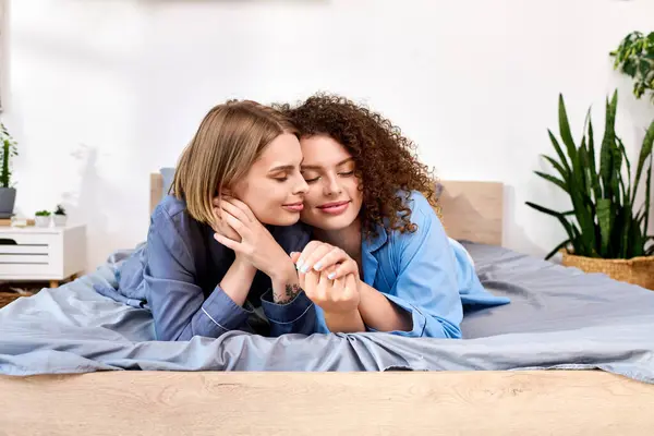 Two women share a tender embrace while relaxing indoors, expressing love and connection. — Stock Photo