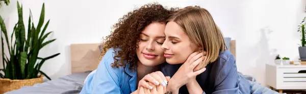 Two young women embrace lovingly in a serene bedroom, sharing a tender moment of joy. — Stock Photo