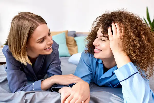 A joyful couple shares laughter and affection while lounging on their bed, embracing intimacy. — Stock Photo