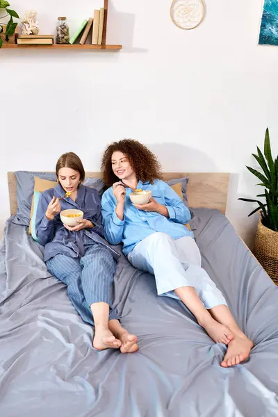 A young couple shares smiles and cereal in their cozy bed. — Stock Photo