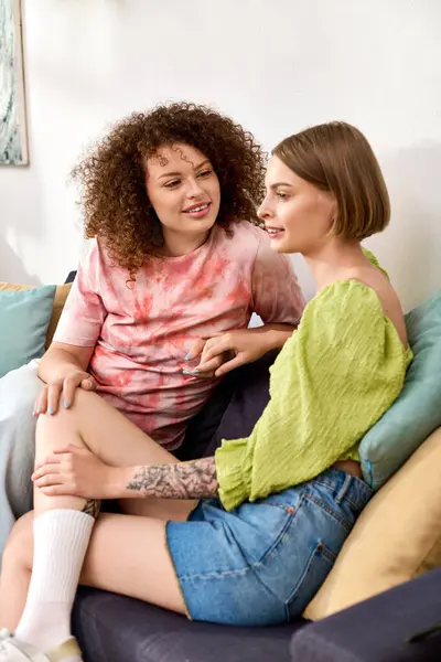Two women share laughter and affection while relaxing together in their cozy living space. — Stock Photo