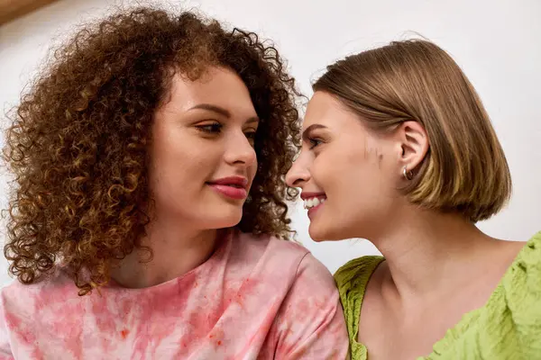Two joyful women share an affectionate gaze, enjoying each others company in a warm space. — Stock Photo