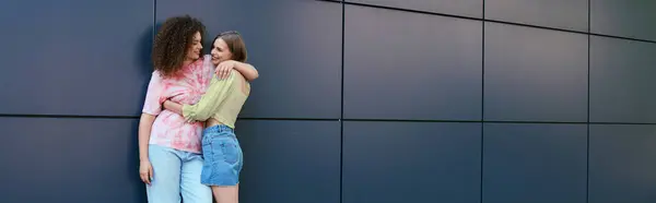 Two women share a loving moment together, laughing and enjoying their time in the city. — Stock Photo