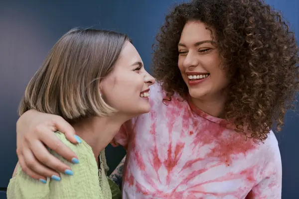 Duas jovens se abraçam com sorrisos alegres, capturando um momento de amor e felicidade. — Fotografia de Stock