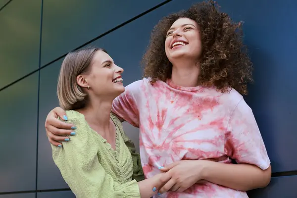 A young couple laughs and shows affection in a lively city atmosphere. — Stock Photo