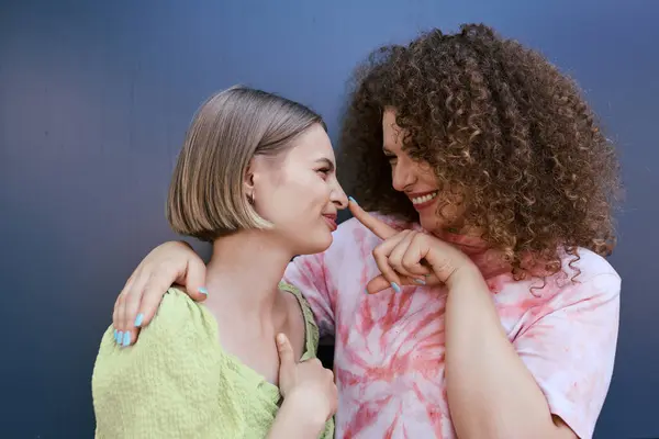 A young lesbian couple playfully enjoying their time together, smiles lighting up their faces. — Stock Photo