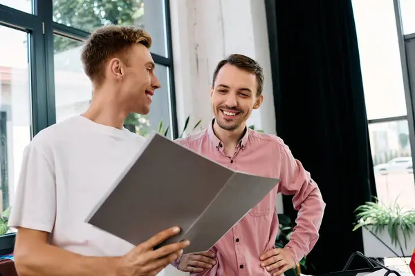 Dois homens conversam animadamente, compartilhando ideias e sorrisos em um escritório elegante. — Fotografia de Stock