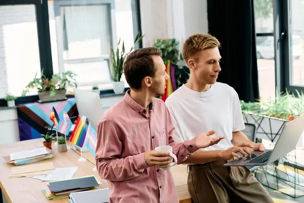 Two stylish men engage in a lively discussion while working in a bright office setting. — Stock Photo