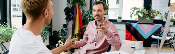 Двоє елегантних чоловіків поділяють жваву дискусію, оточену зеленню і барвистим декором. — стокове фото