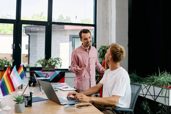 Two charming individuals engage in a joyful conversation amidst a vibrant workspace. — Stock Photo