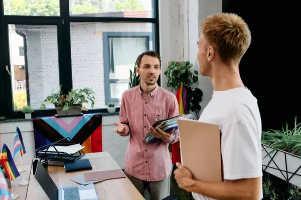 Dois homens bonitos estão tendo uma conversa animada em um ambiente de escritório brilhante e moderno. — Fotografia de Stock