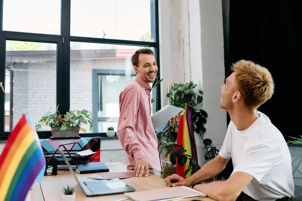 Two joyful partners share laughter and conversation in their vibrant office environment. — Stock Photo