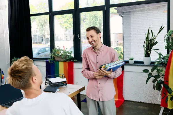Two men smile warmly at each other in a chic office filled with plants and colors. — Stock Photo