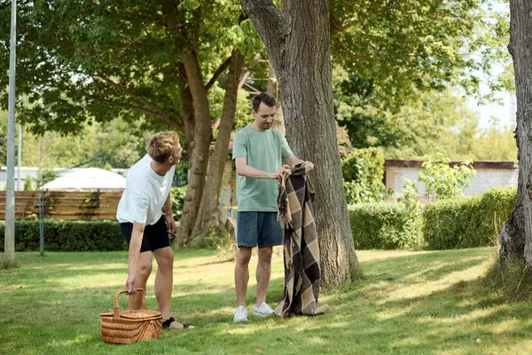 Two partners enjoy a sunny day outdoors, preparing for a delightful picnic together. — Stock Photo