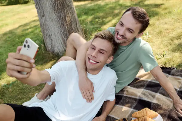 Dos hombres comparten un momento encantador juntos, capturando su amor mientras disfrutan de un día soleado afuera.. - foto de stock