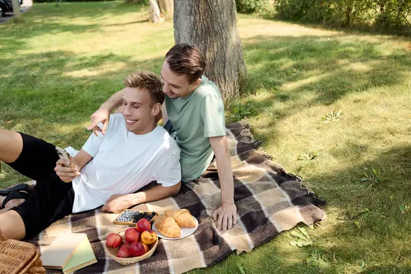 A lovely couple relaxes on a blanket, sharing snacks and enjoying each other company in the sun. — Stock Photo