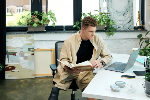 Un joven con una pierna protésica se centra en su trabajo mientras está sentado en un elegante escritorio de oficina. - foto de stock