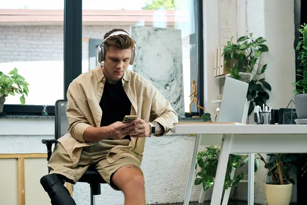 A talented young man with a prosthetic leg focuses on his tasks in a stylish modern office space. — Stock Photo