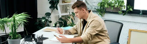 A young professional engages in work tasks at a stylish, plant-filled office. — Stock Photo