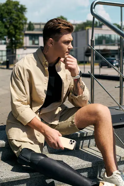 A young man with a prosthetic leg is deep in thought while working in a contemporary office environment. — Stock Photo