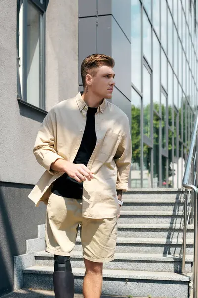A young man with a prosthetic leg strides confidently through a contemporary office space. — Stock Photo