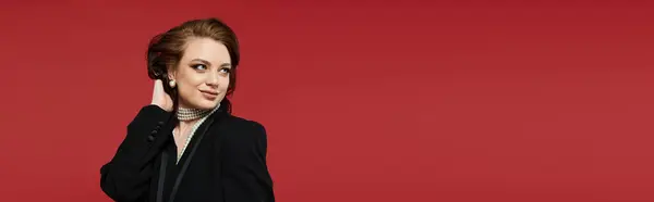 A young woman dressed elegantly showcases her style and confidence against a bold red backdrop. — Stock Photo
