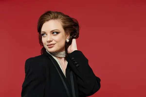 The young woman showcases her beauty and elegance with a confident smile against a bold background. — Stock Photo