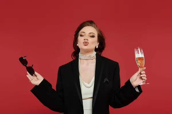 This young woman exudes confidence in an elegant outfit, holding sunglasses and champagne. — Fotografia de Stock