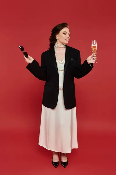 Vestida com um traje deslumbrante, uma jovem brinca alegremente com champanhe, exalando elegância. — Fotografia de Stock