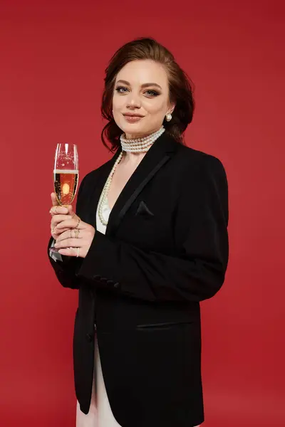 Dressed beautifully in formal attire, a young woman raises her champagne glass in celebration. — Stock Photo