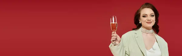 A stylish young woman raises her glass, exuding confidence and elegance in vibrant surroundings. — Stock Photo
