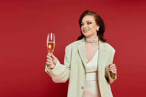 The beautiful woman raises a glass to celebrate, exuding charm and sophistication. — Stock Photo