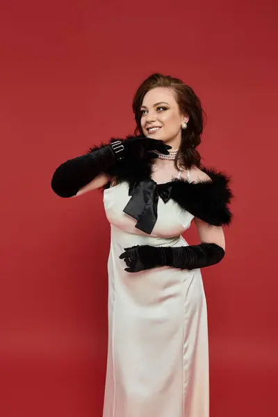 Dressed in an elegant gown, a young woman poses gracefully with charm and style. — Stock Photo
