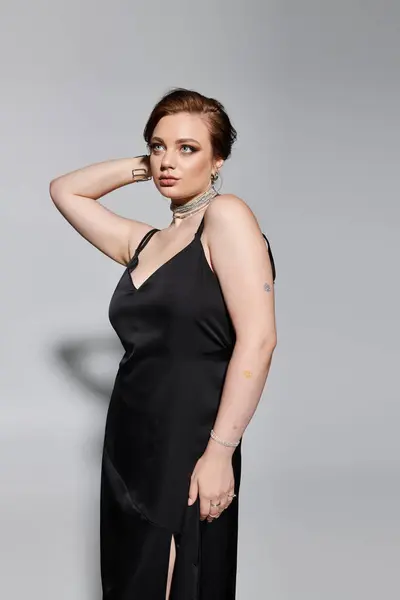 A beautiful young woman showcases her elegance in a chic black outfit, exuding confidence. — Stock Photo