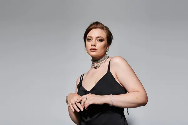 Dressed in a stylish black outfit, she poses gracefully, showcasing elegance and poise. — Stock Photo