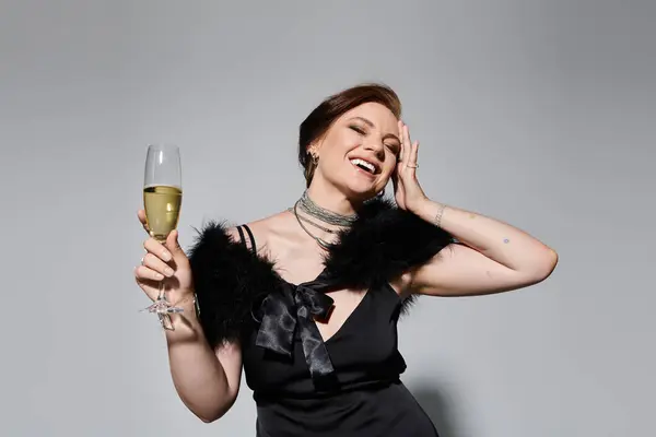 A young, beautiful woman enjoys a moment of joy while holding a glass of champagne gracefully. — Stock Photo