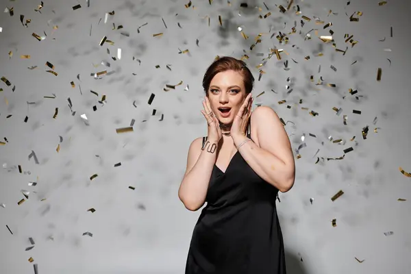 A young woman in elegant attire joyfully revels as confetti falls around her. — Stock Photo