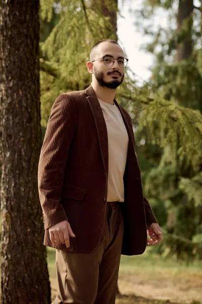 Handsome man in fashionable autumn attire embrace the beauty of nature in a scenic field. — Stock Photo