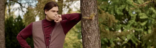 Handsome man clad in trendy autumn attire in relaxed pose standing amid the vibrant fall landscape. — Stock Photo