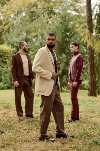 Handsome men showcase their autumn fashion while enjoying a picturesque autumn field filled with foliage. — Stock Photo