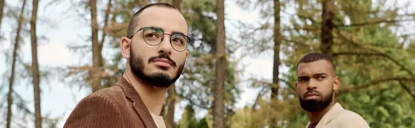 Zwei gut aussehende Männer präsentieren modische Herbstkleidung und genießen einen ruhigen Moment in der Schönheit der Natur. — Stockfoto