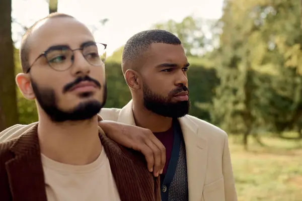 Handsome gentlemen in trendy autumn outfits enjoy a serene moment in a vibrant outdoor setting. — Stock Photo