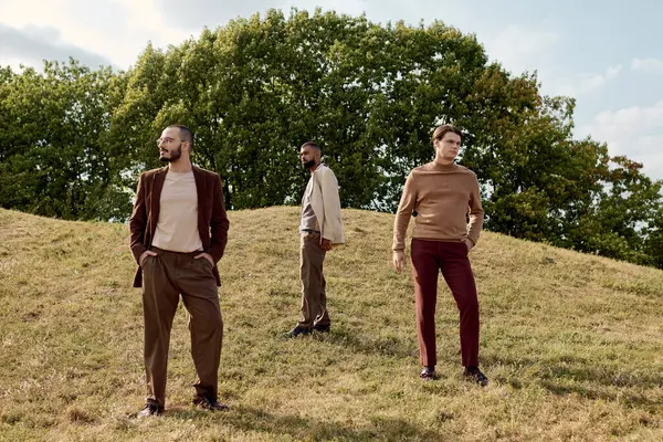 Three stylishly dressed men enjoy a serene moment in an autumn field, surrounded by vibrant foliage. — Stock Photo