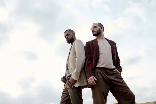 Beaux hommes habillés dans des tenues d'automne à la mode profiter d'un moment tranquille dans un beau champ. — Photo de stock