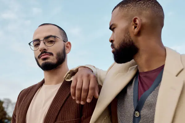 Two handsome men wear stylish autumn outfits while posing together in a picturesque field. — Stock Photo