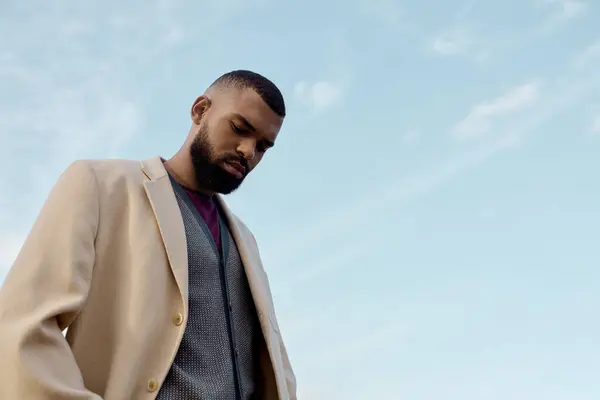 Um homem contemplativo vestido de moda elegante outono fica em um campo tranquilo, cercado pela beleza da natureza.. — Fotografia de Stock