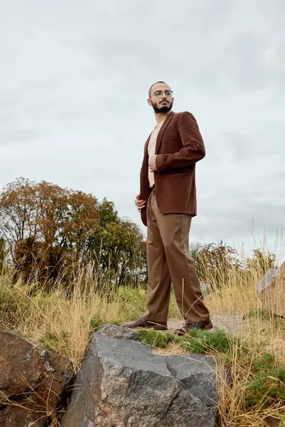 A dapper man stands proudly in a field, embracing the beauty of autumn with fashionable attire. — Stock Photo